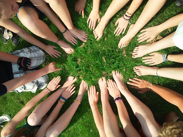 Groupe de jeunes gens formant un cercle avec leurs mains et leurs pieds.