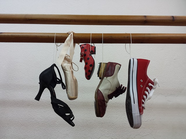 Différents types de chaussures de danse suspendues à une barre.