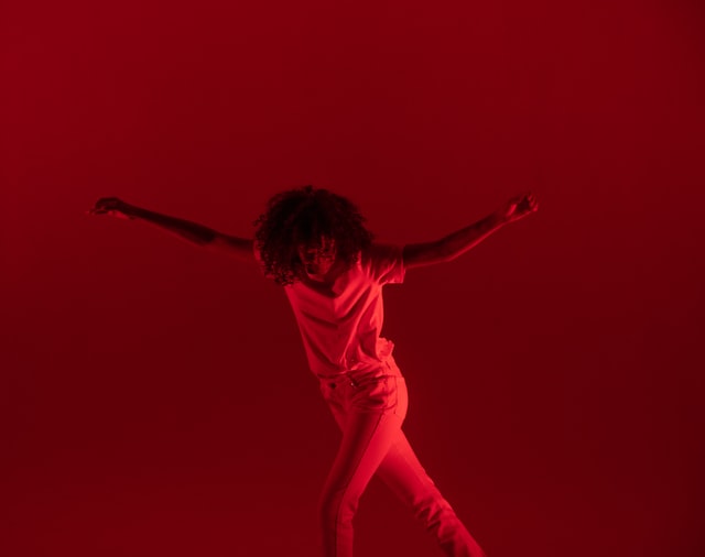 Femme qui danse dans une ambiance rouge.